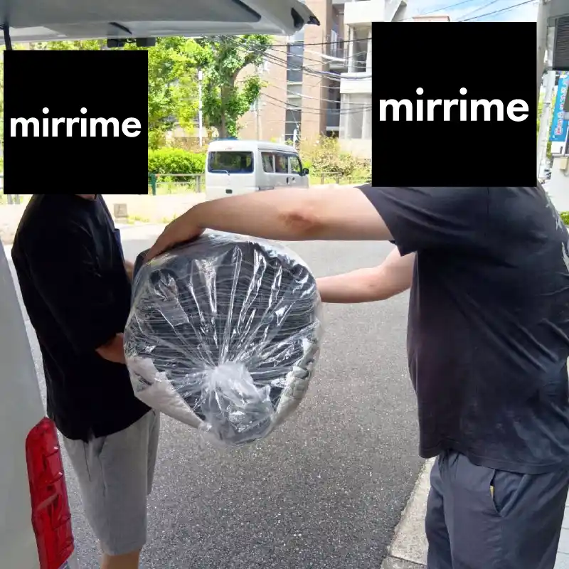 製品を外へ運び出すために建物から出てくる利用者さんと職員の姿