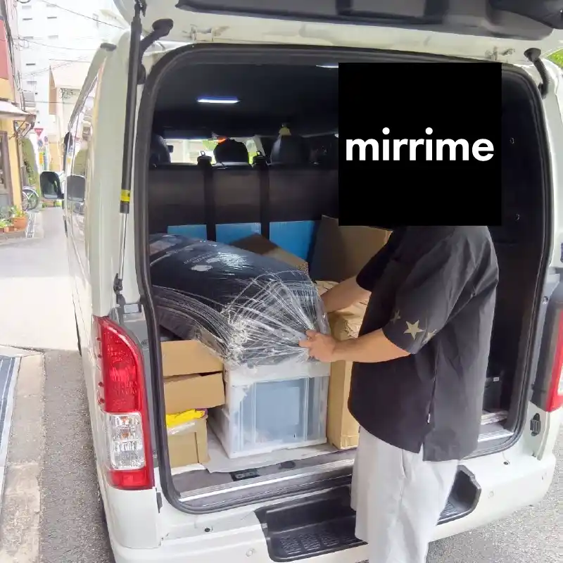 納品物を社用車の荷台に積み込む利用者さんの様子。荷物の配置にも気を配っている