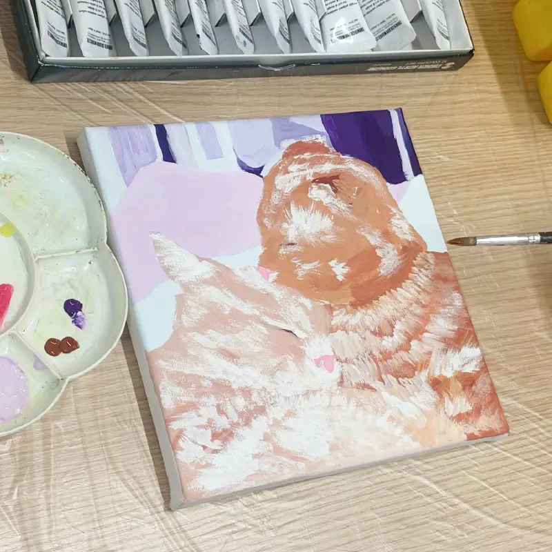 写真を見ながらキャンバスに描かれるペットのイラスト