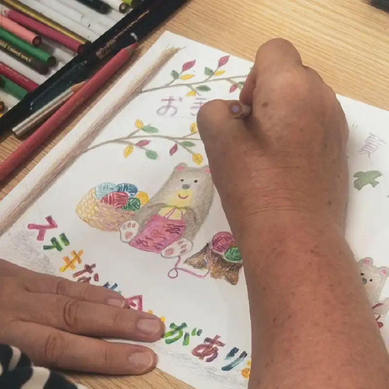 利用者さんが色鉛筆でファインアートを描いている様子