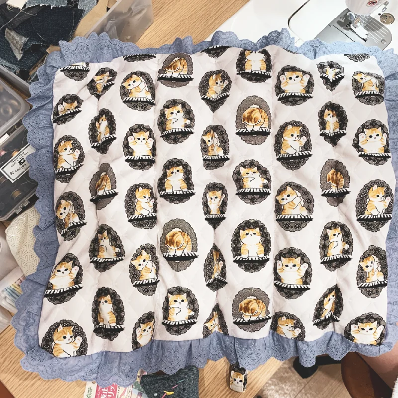 猫柄クッションの裏面。シンプルな仕立てで表面のデザインを引き立てる。