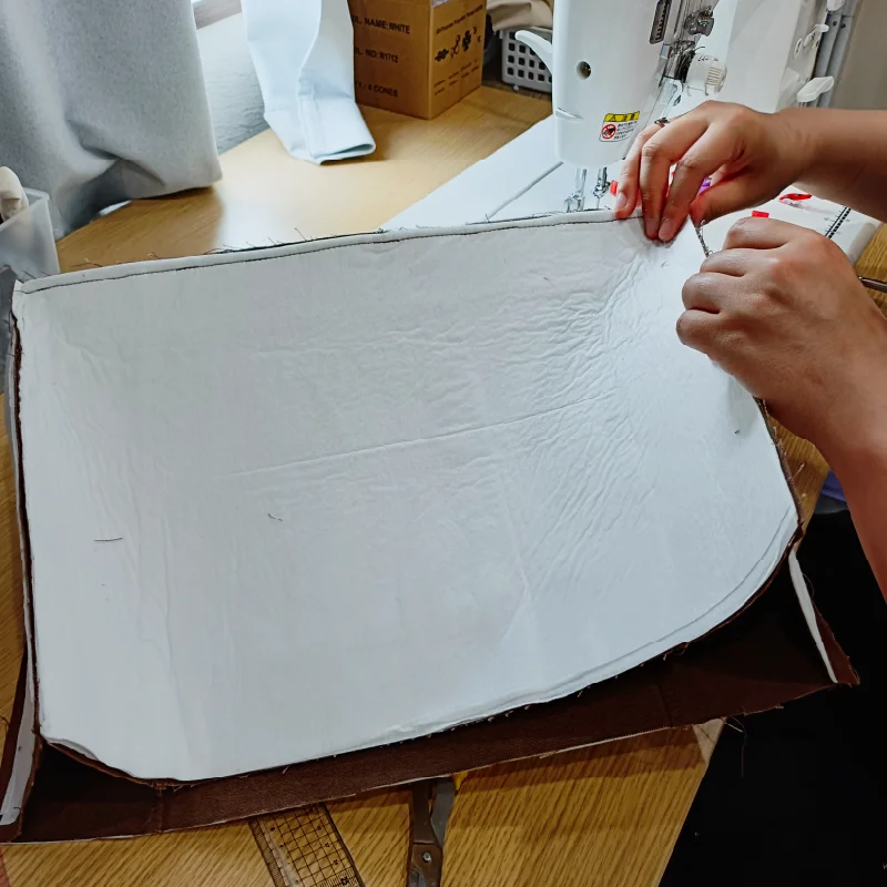バッグの縫製具合を確認する利用者さん