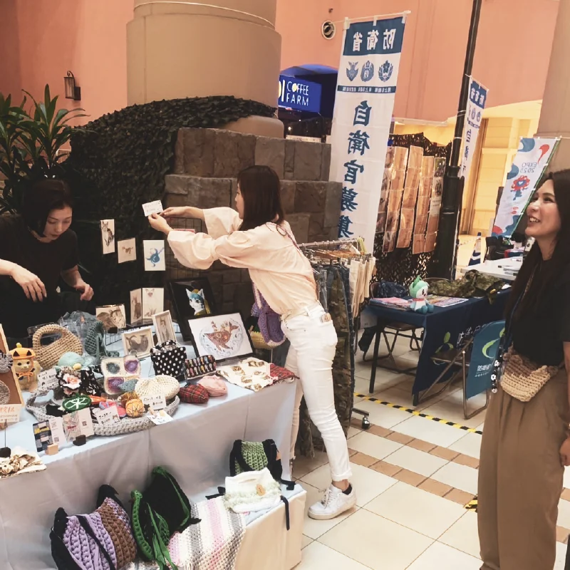 「つかねこ CAT EXPO 2025でブースを整える女性職員」