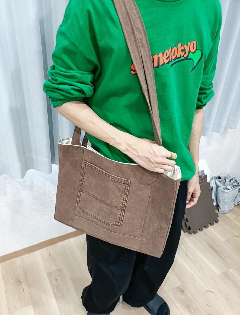完成したトートバッグを持つ職員