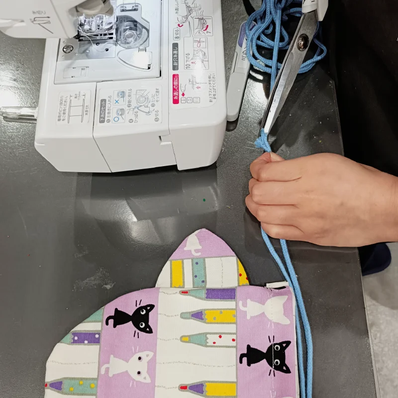 巾着紐の長さ調整をする利用者さん