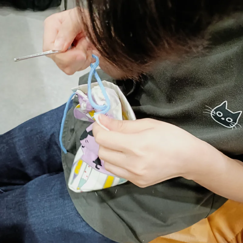巾着袋に紐を通す作業