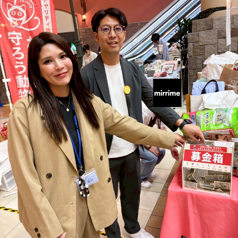 募金箱を指さす職員2人