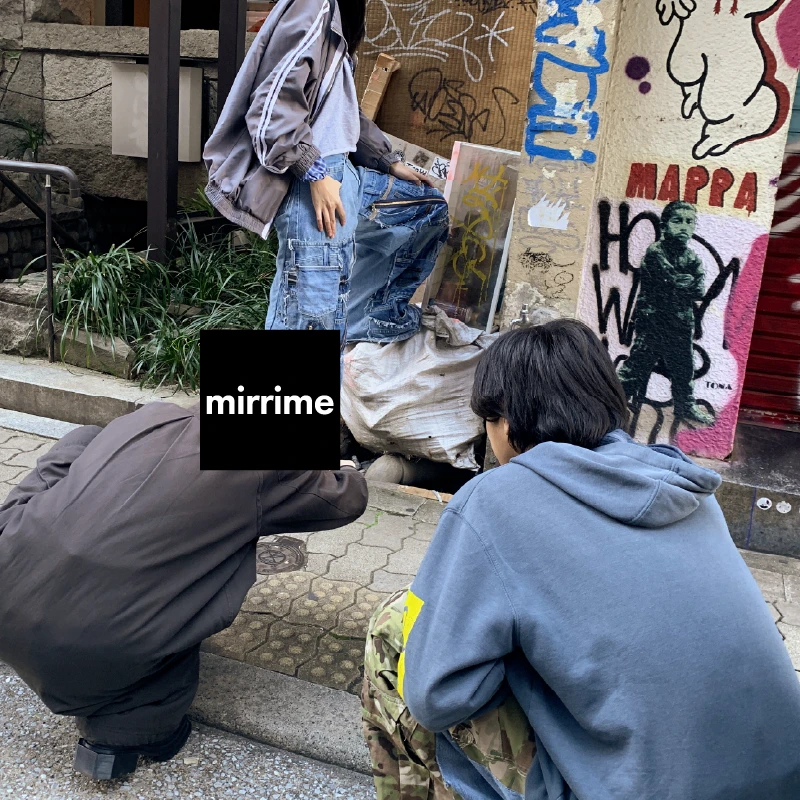 グラフィティを背景にリメイクデニムを着用して撮影する利用者さん