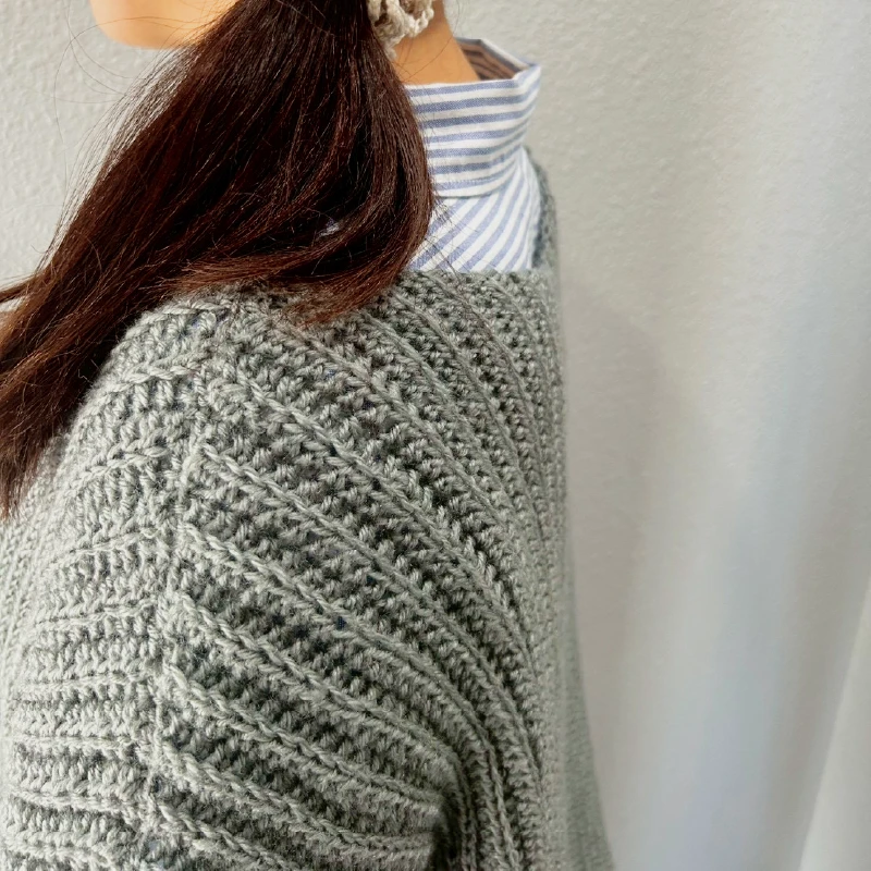 ニットの袖口や編み目のディテールを写した画像