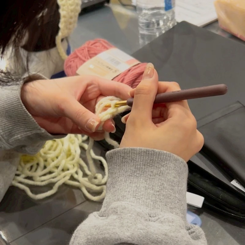 チームで並びながら編み物を続ける様子