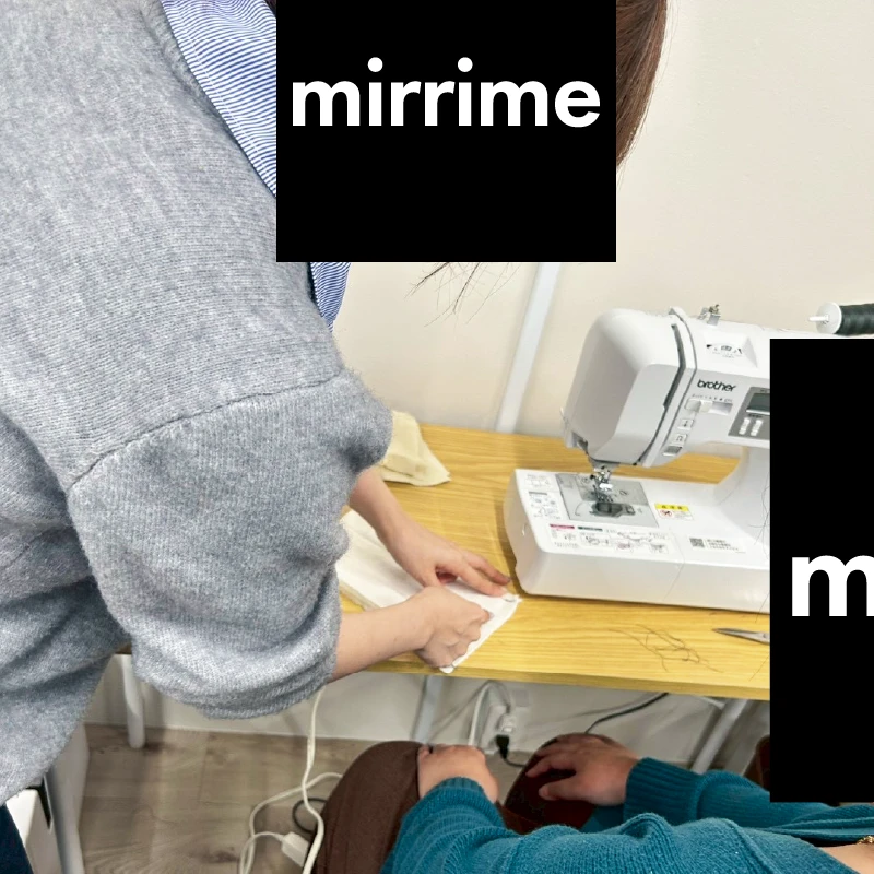 職員が利用者さんにミシンの使い方を教えているところ