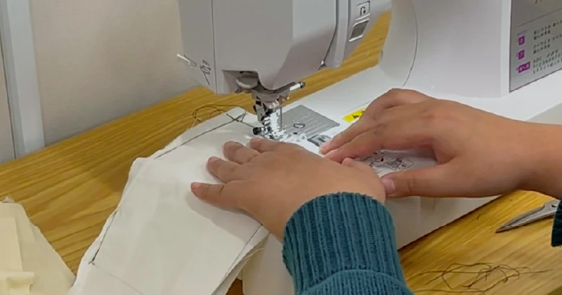 就労継続支援A型事業所で職員が利用者さんにミシンの使い方を教えている様子