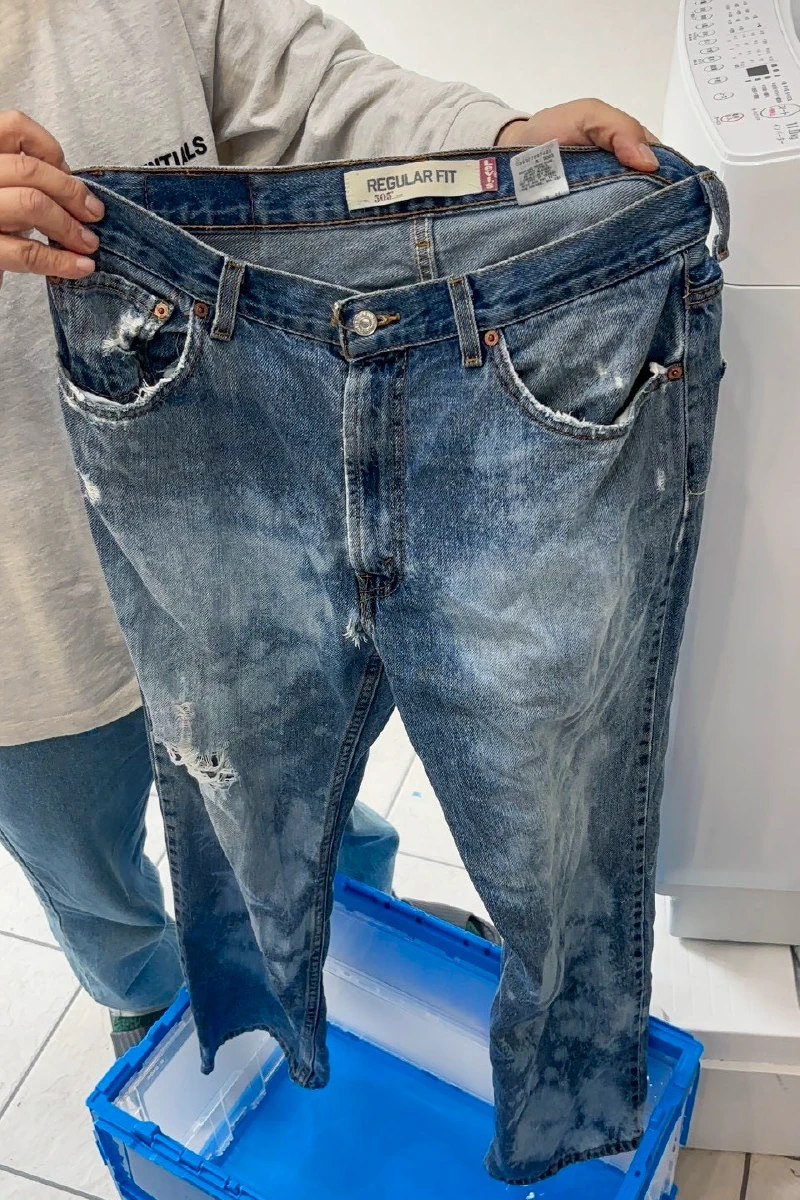 デニム全体の色の抜け具合を確認する利用者さん