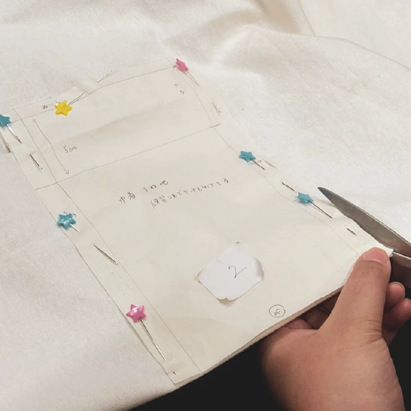 巾着制作の最初の工程として布を仮止めしている様子