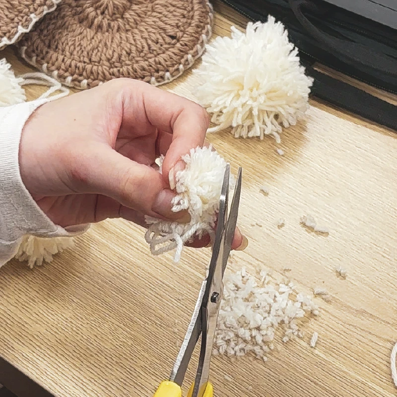 整えたぽんぽんの形をハサミでカットしている様子