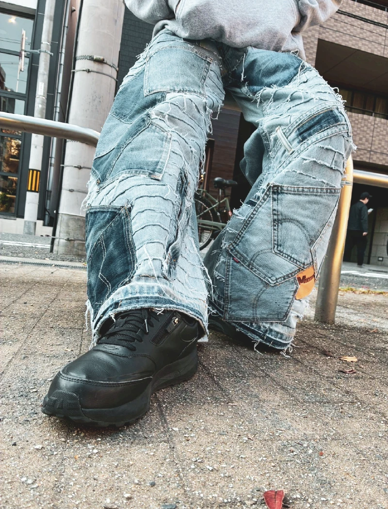 リメイクデニムを着用した利用者さんが堀江の街角で正面に立つ様子。