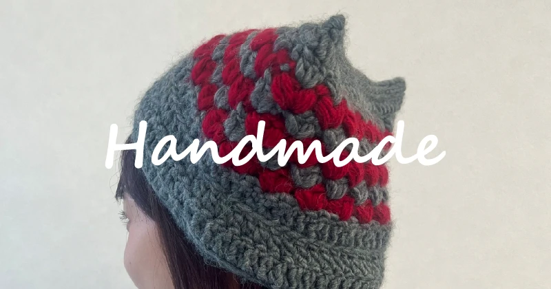 利用者さんが制作した猫耳付きのニット帽を手に持っている様子